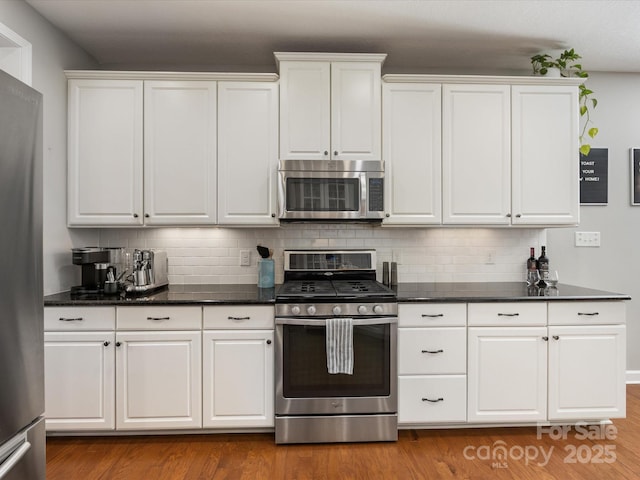 kitchen with white cabinets, light hardwood / wood-style floors, backsplash, and appliances with stainless steel finishes