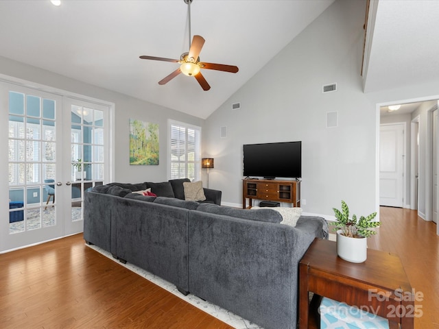 living room with french doors, high vaulted ceiling, ceiling fan, and wood-type flooring