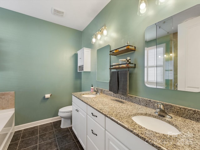 bathroom with tile patterned floors, a washtub, vanity, and toilet