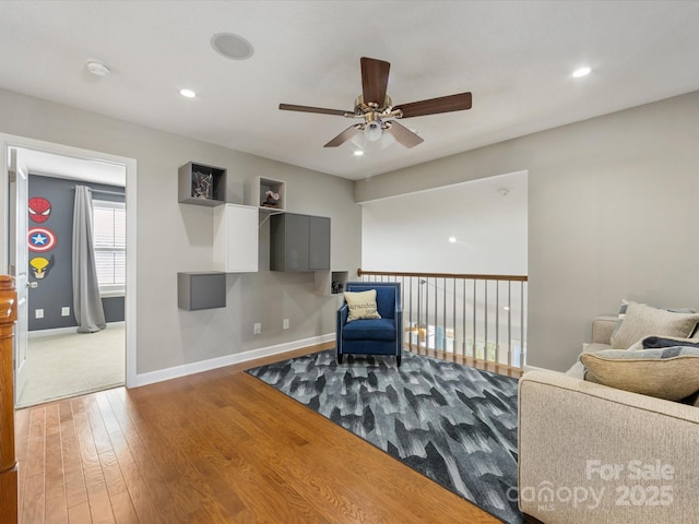 sitting room with hardwood / wood-style floors and ceiling fan