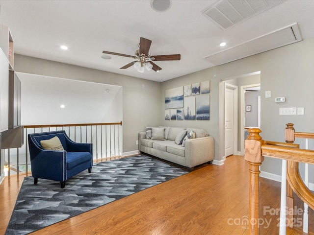 living room featuring ceiling fan and hardwood / wood-style flooring