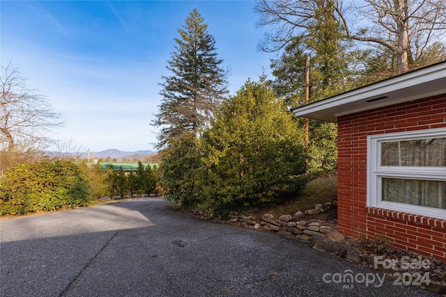 view of property exterior with a mountain view and a patio