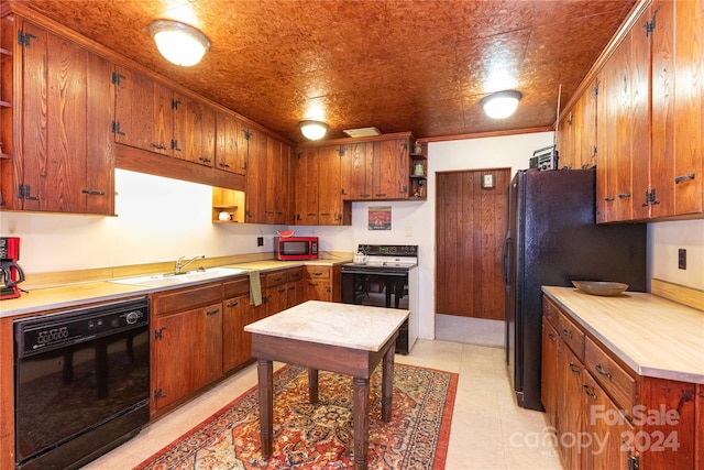 kitchen featuring crown molding, sink, light tile patterned floors, and black appliances