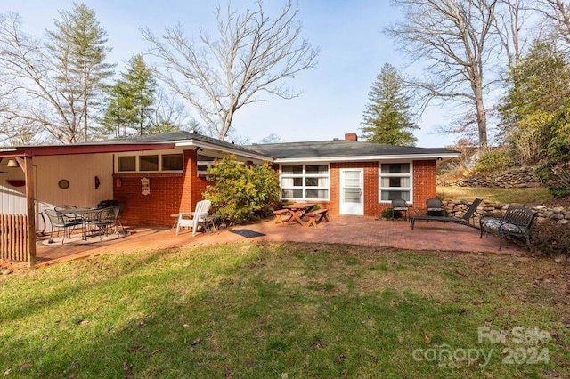 rear view of property featuring a yard and a patio