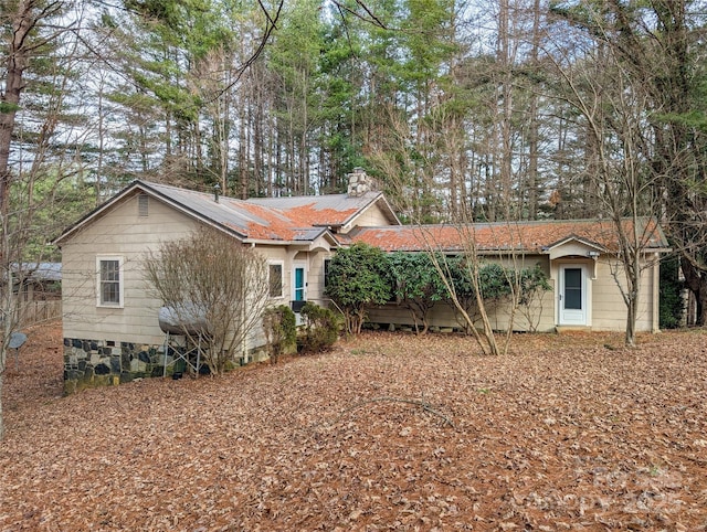 exterior space featuring metal roof and a chimney