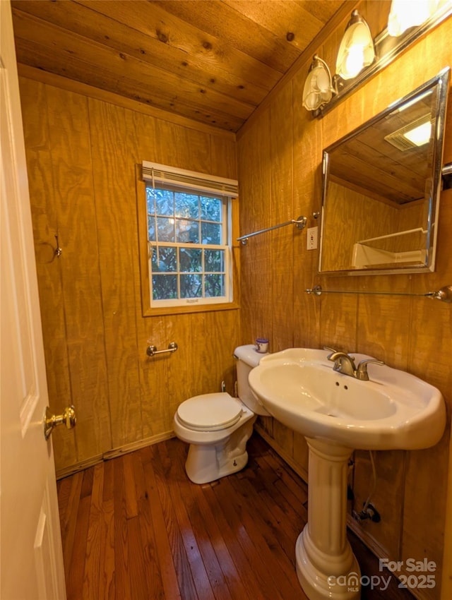 bathroom with wooden walls, toilet, wood ceiling, and hardwood / wood-style flooring