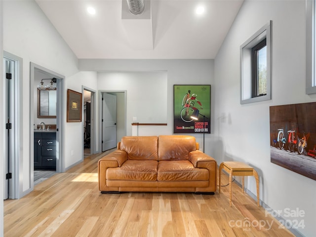 living room with sink, vaulted ceiling, and hardwood / wood-style flooring