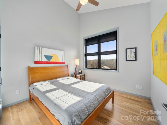 bedroom featuring ceiling fan, light wood-type flooring, and lofted ceiling