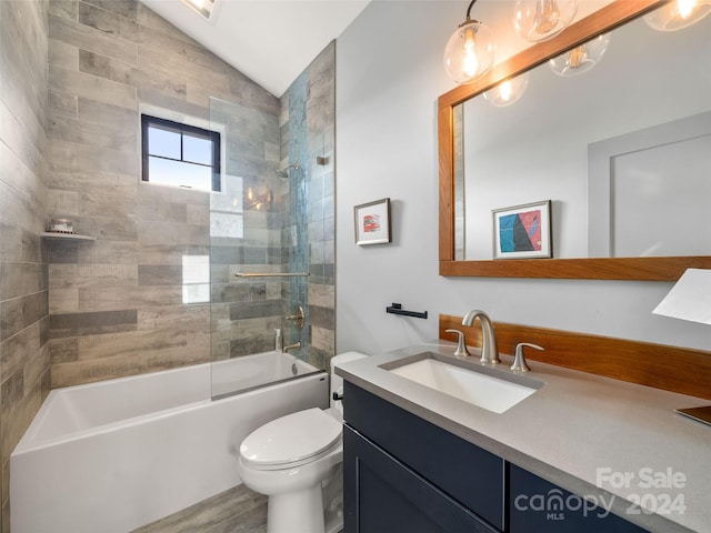 full bathroom with vanity, wood-type flooring, toilet, tiled shower / bath, and lofted ceiling