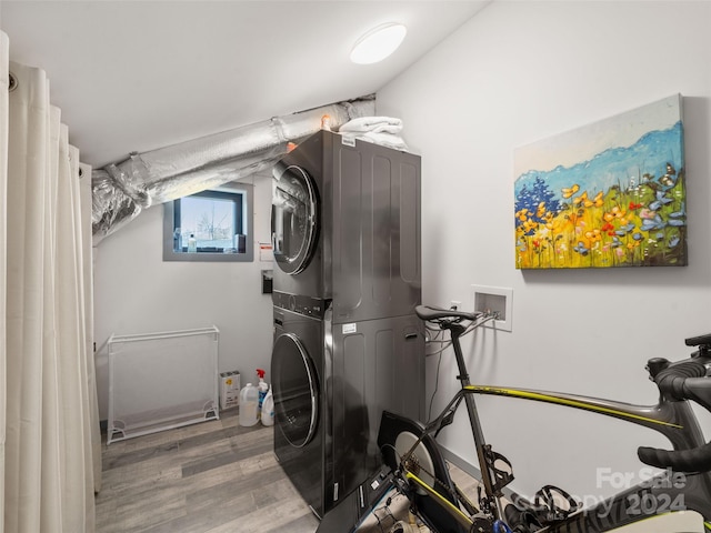 utility room with stacked washer / drying machine