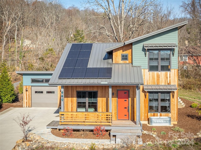 view of front of home featuring solar panels, a garage, and a porch