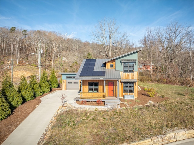 view of front of home featuring solar panels, a front lawn, and an outdoor structure