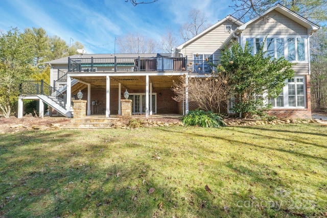 back of property with a wooden deck and a yard