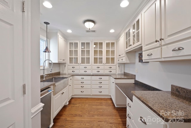 kitchen with dishwasher, sink, white cabinets, dark stone counters, and hanging light fixtures