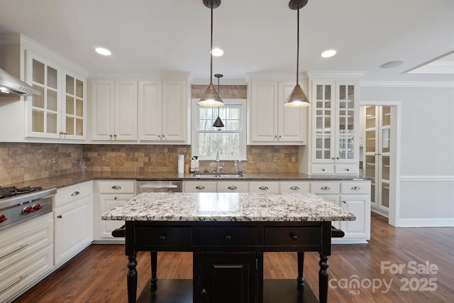 kitchen with a center island, sink, hanging light fixtures, and white cabinets