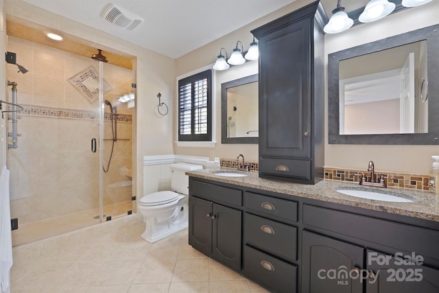 bathroom featuring vanity, tile patterned floors, a shower with door, and toilet