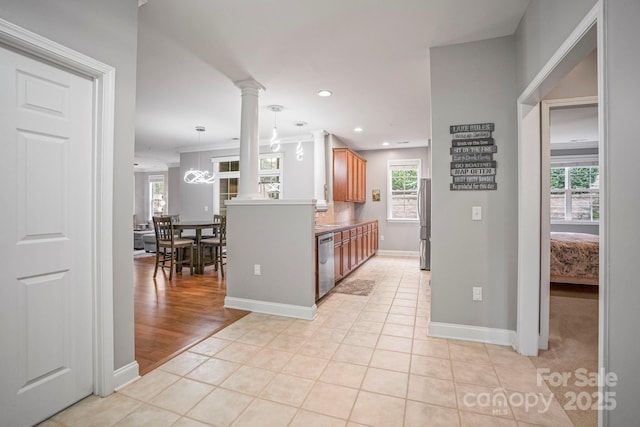 kitchen with ornate columns, a healthy amount of sunlight, light tile patterned floors, and stainless steel appliances