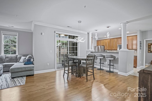 dining space featuring light hardwood / wood-style flooring, a chandelier, and ornamental molding