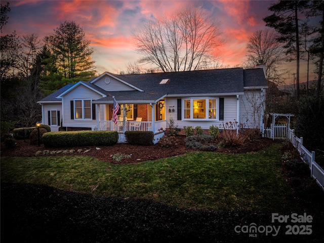 ranch-style home featuring a porch and a yard