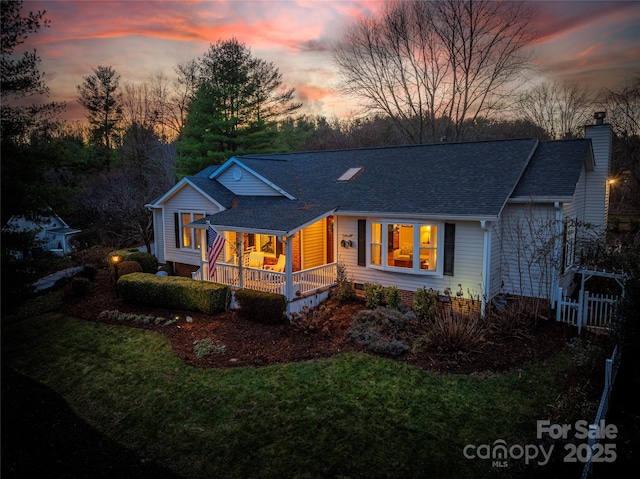 ranch-style home featuring a yard and a porch