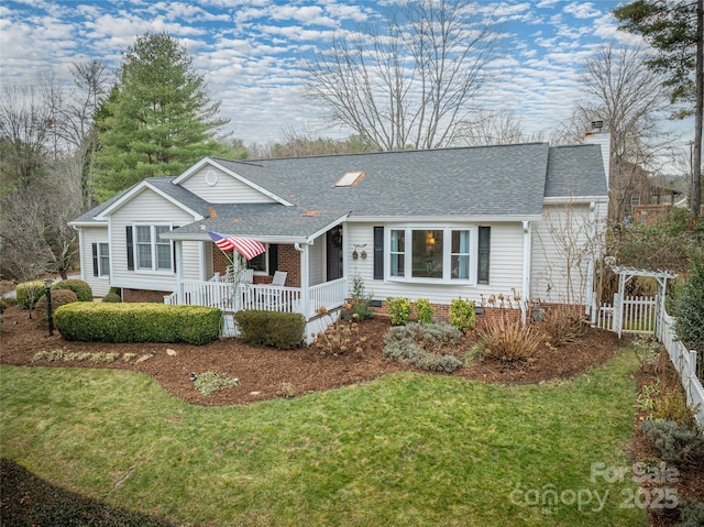 ranch-style home featuring a front lawn and covered porch