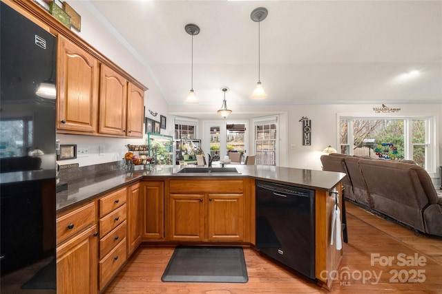 kitchen featuring pendant lighting, dishwasher, sink, light wood-type flooring, and kitchen peninsula