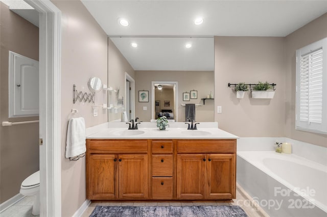 bathroom featuring a bathing tub, tile patterned flooring, plenty of natural light, toilet, and vanity