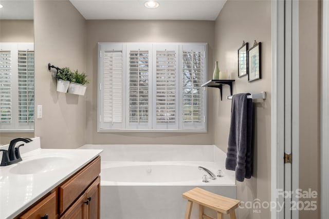 bathroom with vanity and a tub