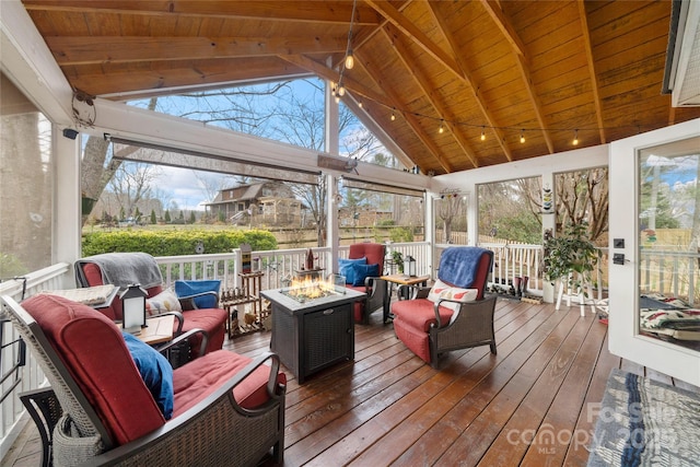 sunroom with vaulted ceiling with beams, a healthy amount of sunlight, and wood ceiling