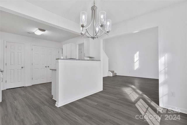 unfurnished dining area with a chandelier and dark hardwood / wood-style flooring