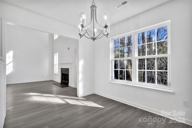 unfurnished living room with a chandelier and dark wood-type flooring