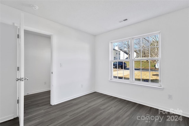 unfurnished room with dark hardwood / wood-style flooring