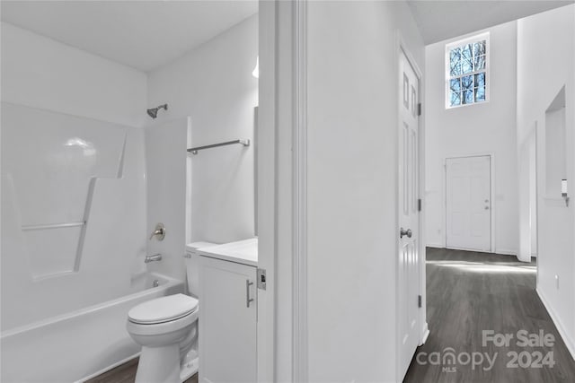 full bathroom with toilet, vanity, wood-type flooring, and tub / shower combination