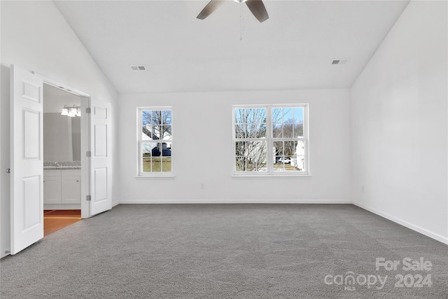 spare room featuring carpet flooring, vaulted ceiling, and ceiling fan