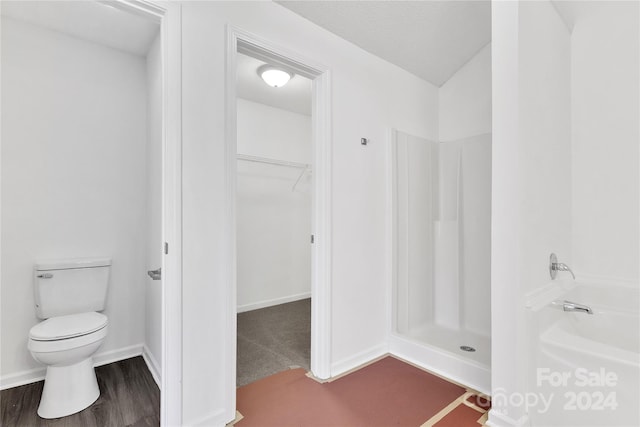 bathroom featuring hardwood / wood-style floors, toilet, and walk in shower