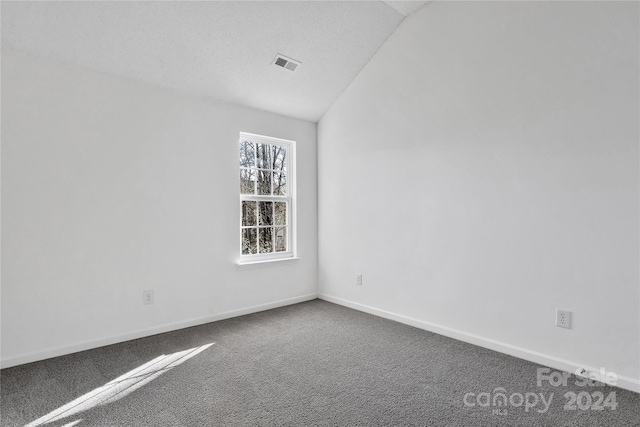 carpeted empty room with lofted ceiling