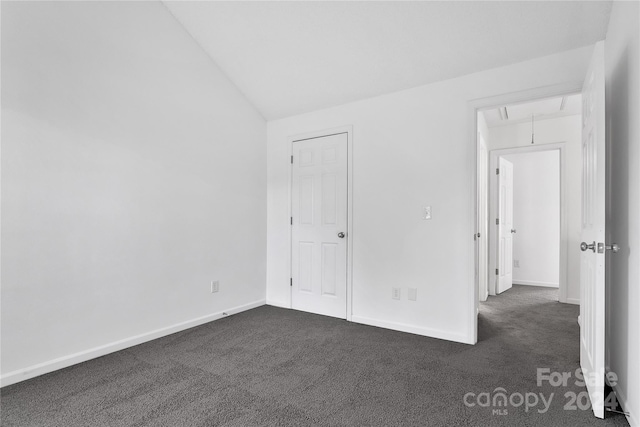 unfurnished bedroom featuring dark carpet and lofted ceiling