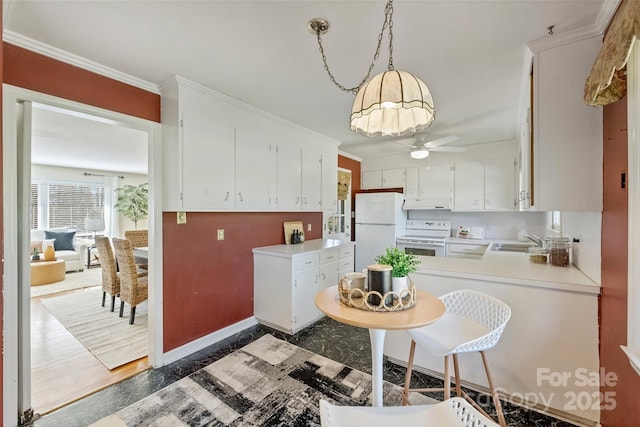 kitchen with white appliances, hanging light fixtures, ornamental molding, white cabinets, and sink