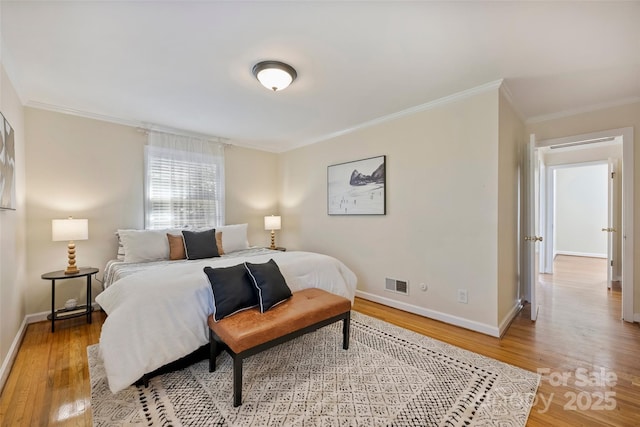 bedroom with ornamental molding and hardwood / wood-style floors