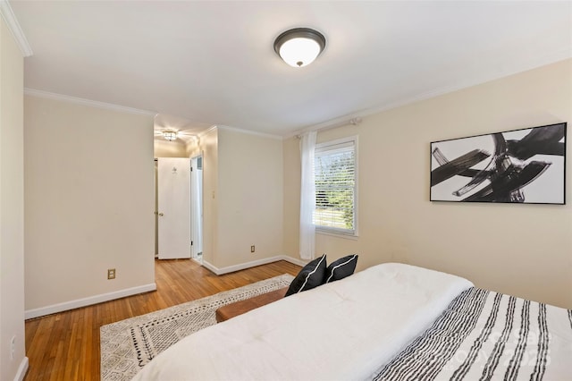 bedroom with wood-type flooring and ornamental molding