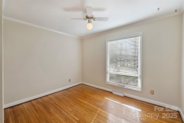 empty room with ceiling fan, crown molding, and light hardwood / wood-style floors