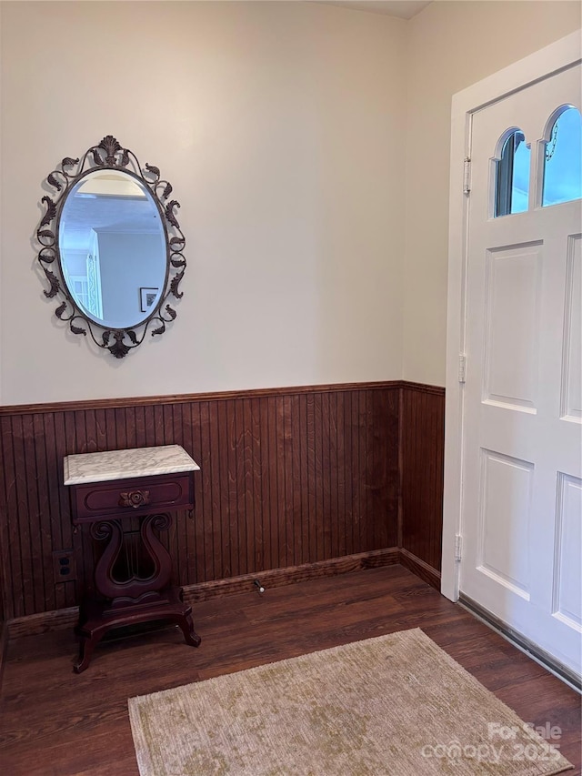 foyer featuring wooden walls and dark hardwood / wood-style floors