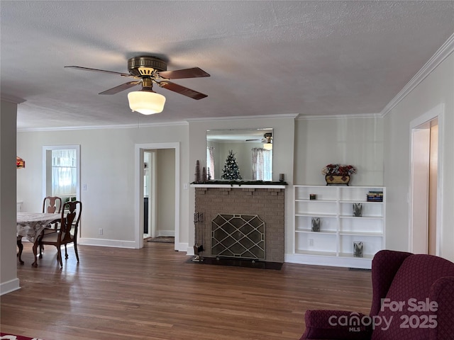 living room featuring crown molding, a brick fireplace, a textured ceiling, dark hardwood / wood-style flooring, and ceiling fan