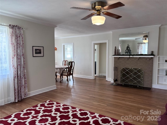 living room featuring crown molding, hardwood / wood-style floors, and a brick fireplace