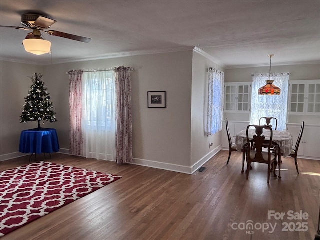 unfurnished dining area with crown molding, ceiling fan, and dark hardwood / wood-style floors