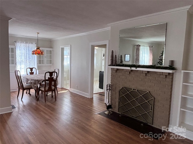 dining area featuring crown molding, dark hardwood / wood-style floors, and a fireplace