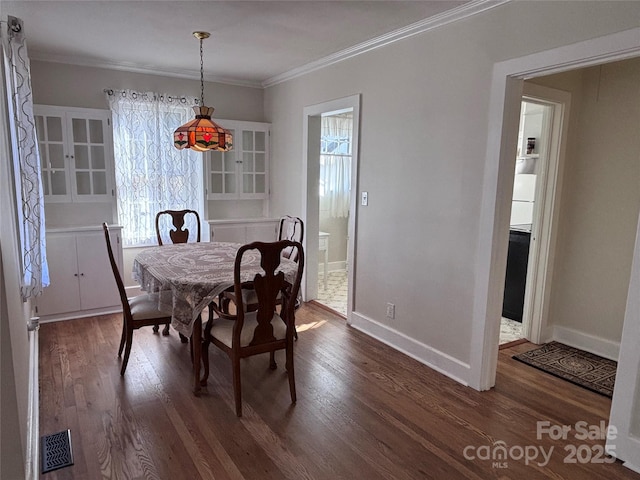 dining area featuring ornamental molding and dark hardwood / wood-style floors