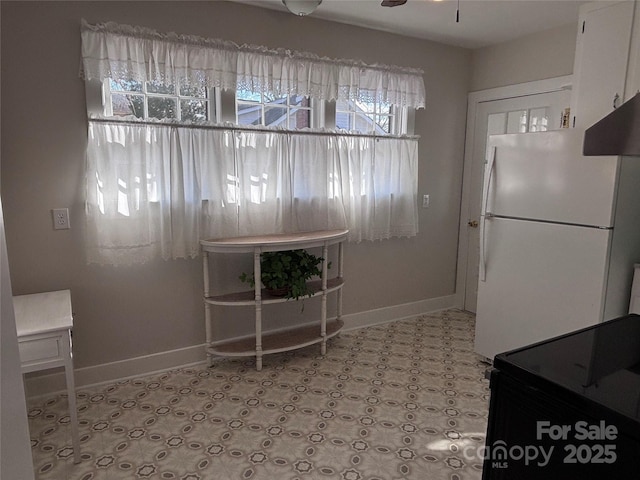 kitchen featuring white cabinetry, white fridge, and ceiling fan