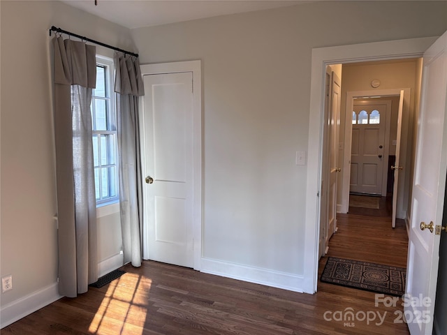 unfurnished bedroom featuring dark wood-type flooring