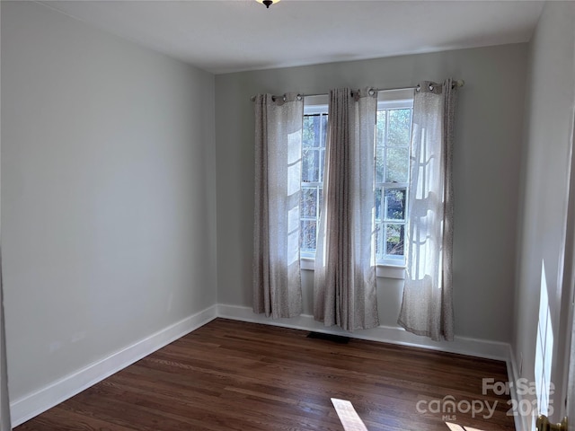 spare room with dark hardwood / wood-style flooring